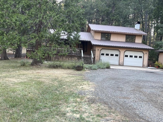 view of front of house featuring covered porch, a front yard, and a garage