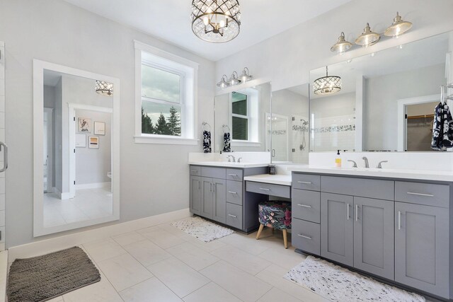 bathroom with tile patterned floors, vanity, walk in shower, and a chandelier