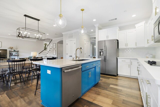 kitchen with sink, a kitchen island with sink, dark hardwood / wood-style floors, white cabinetry, and stainless steel appliances