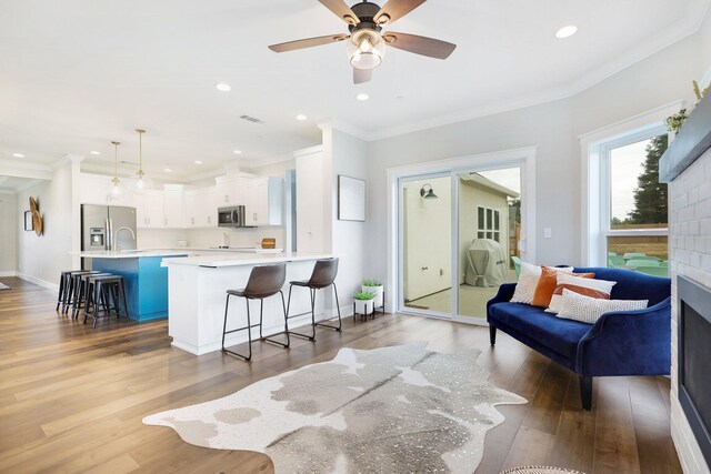 interior space featuring ceiling fan, hardwood / wood-style flooring, and ornamental molding