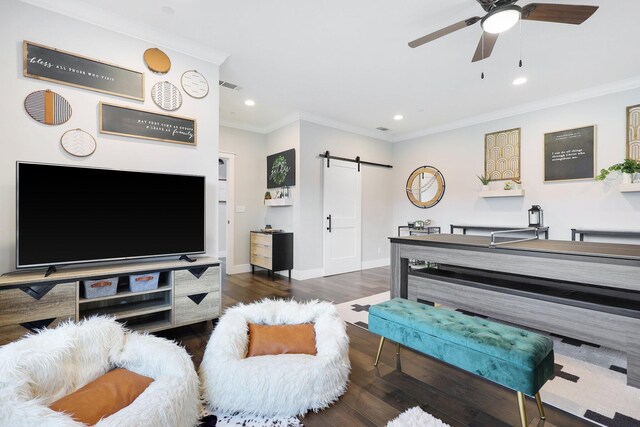 living room featuring dark hardwood / wood-style flooring, crown molding, a barn door, and ceiling fan