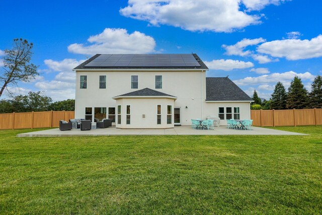 rear view of property with an outdoor living space, a lawn, solar panels, and a patio