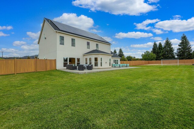 back of house with central AC unit, a patio area, an outdoor hangout area, a yard, and solar panels