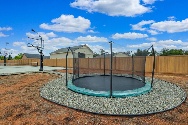 exterior space featuring basketball court and a trampoline