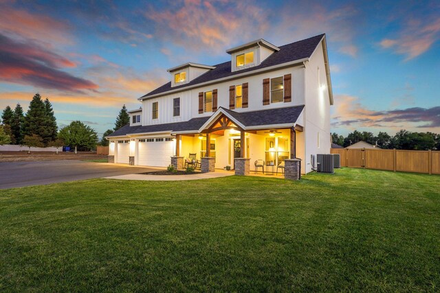 view of front of property with a garage, a lawn, and cooling unit