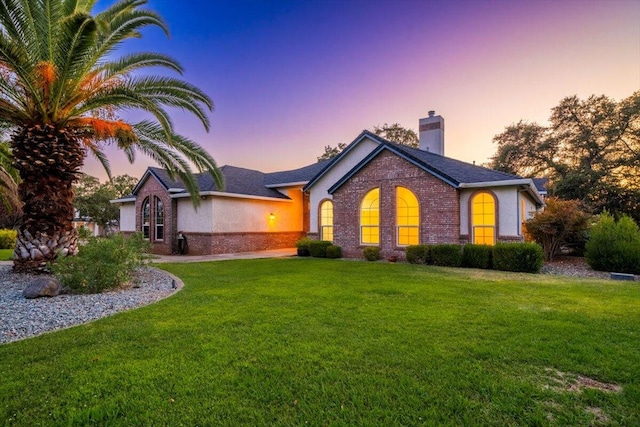 ranch-style home with a lawn