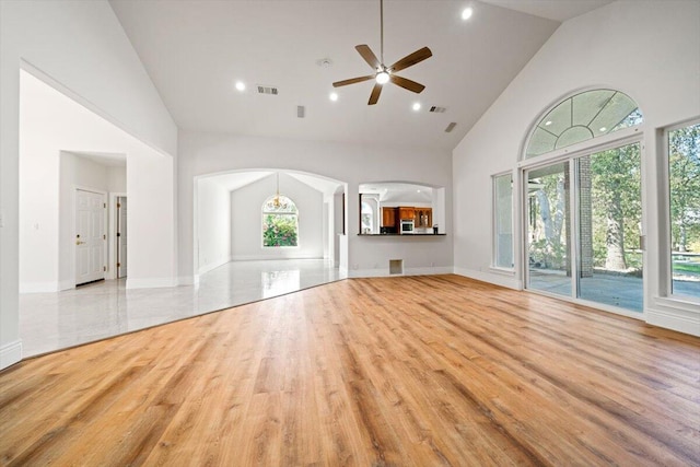 unfurnished living room featuring light wood-type flooring, high vaulted ceiling, and ceiling fan