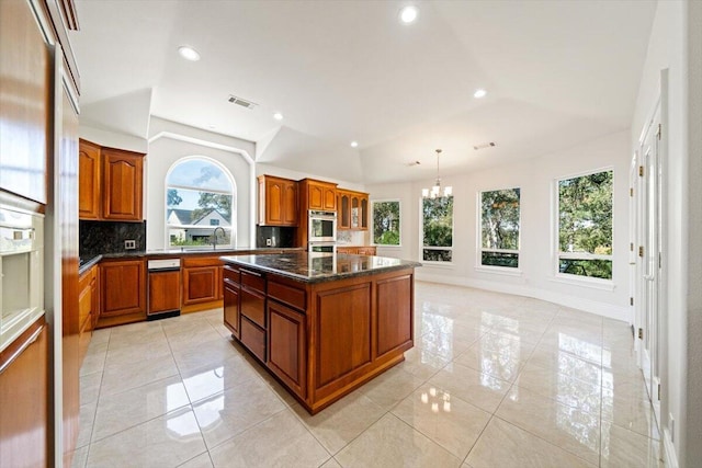 kitchen with pendant lighting, a center island, sink, tasteful backsplash, and a chandelier