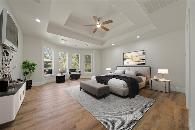 bedroom featuring a tray ceiling, hardwood / wood-style flooring, and ceiling fan