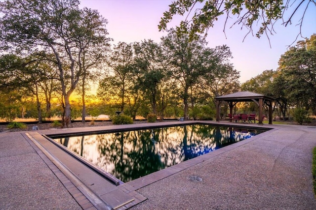 pool at dusk with a gazebo