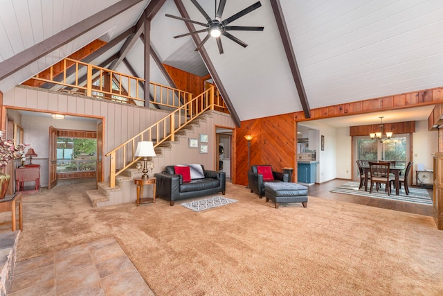 living room featuring beamed ceiling, ceiling fan with notable chandelier, high vaulted ceiling, and wooden walls