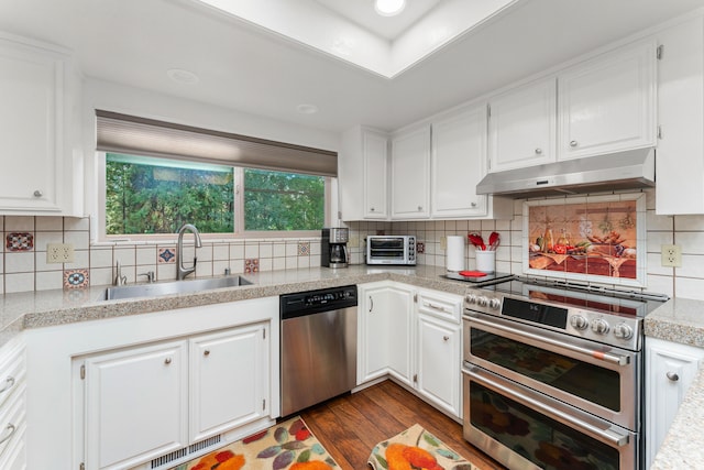 kitchen with sink, stainless steel appliances, dark hardwood / wood-style flooring, and backsplash