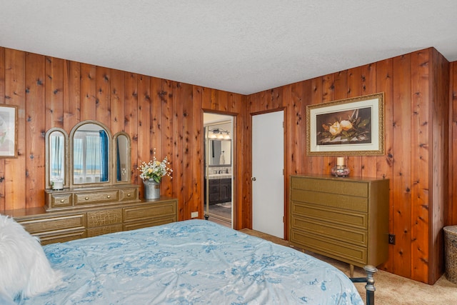 carpeted bedroom featuring a textured ceiling, wooden walls, and connected bathroom