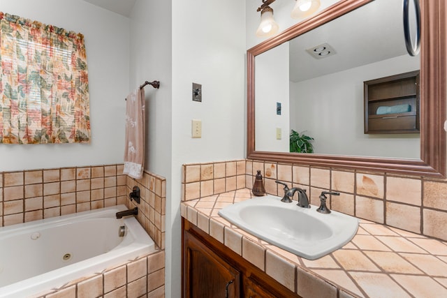 bathroom with decorative backsplash, vanity, and tiled bath