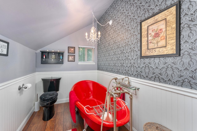 interior space featuring hardwood / wood-style floors, a chandelier, a washtub, and lofted ceiling