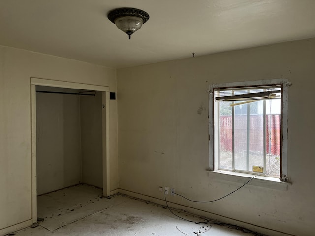 unfurnished bedroom with multiple windows and a closet