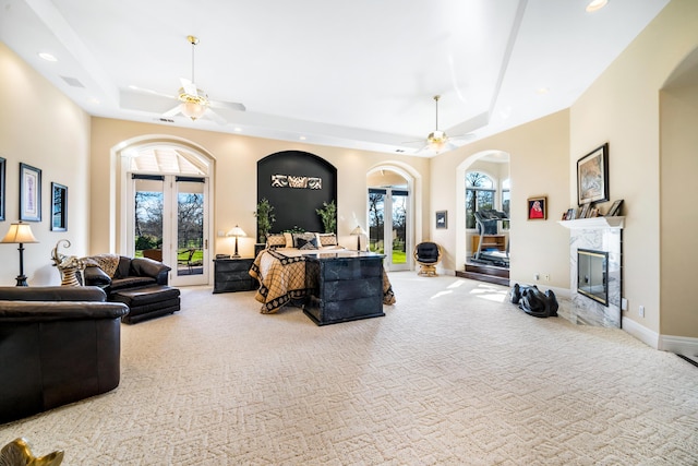 living room featuring ceiling fan, a tray ceiling, and a premium fireplace