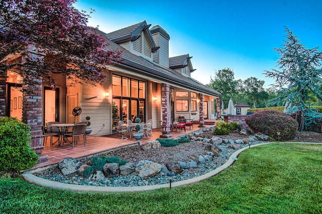 rear view of property with a patio area and a yard