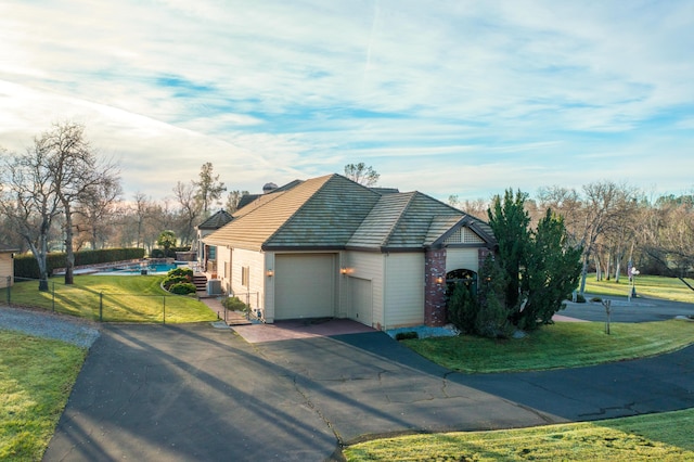 view of property exterior featuring a garage, cooling unit, and a yard