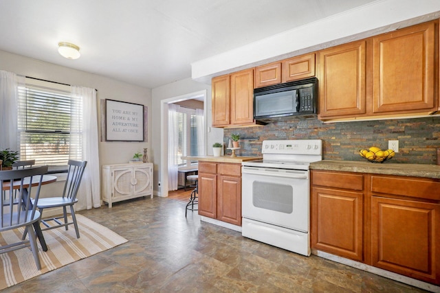 kitchen with white range with electric stovetop, plenty of natural light, and tasteful backsplash