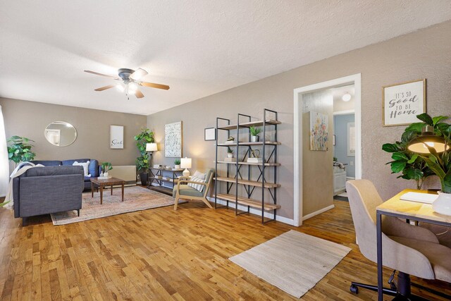 living room with a textured ceiling, hardwood / wood-style floors, and ceiling fan