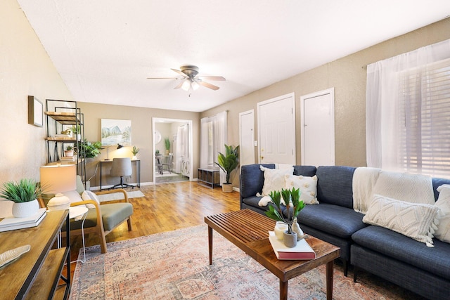 living room with wood-type flooring and ceiling fan