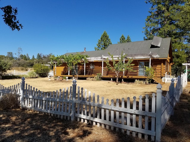 7414 Albers Forest Dr, Shingletown, CA 96088 - back of property with log siding, a fenced front yard, and a wooden deck