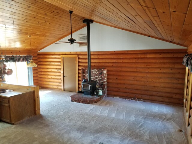 unfurnished living room with carpet, high vaulted ceiling, log walls, a wood stove, and wood ceiling