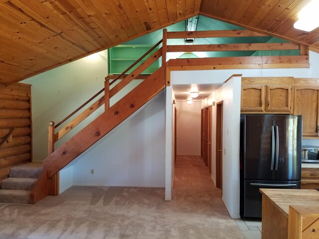 kitchen featuring log walls, black fridge, butcher block counters, wood ceiling, and lofted ceiling