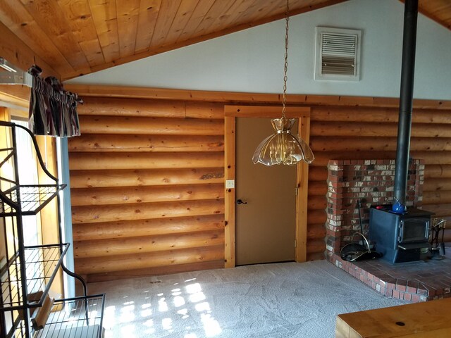 interior space with carpet floors, a wood stove, rustic walls, vaulted ceiling, and wooden ceiling