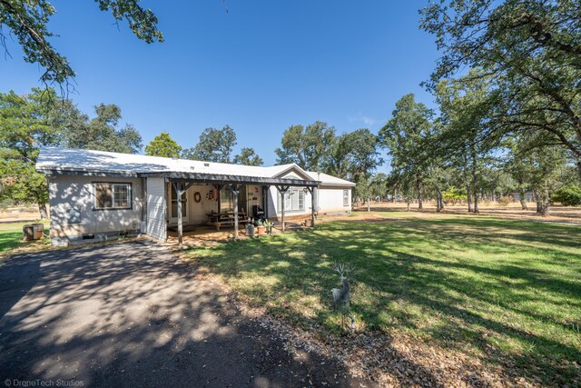 view of front of house with a front yard and a patio area