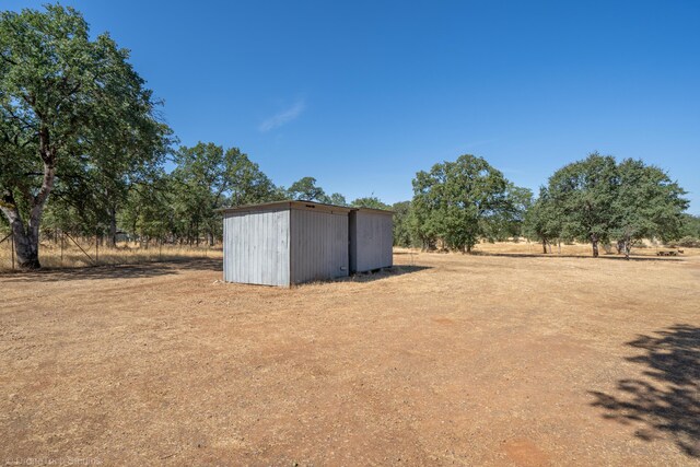 view of yard featuring an outdoor structure and a rural view