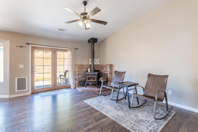 sitting room with a ceiling fan, dark wood finished floors, visible vents, and baseboards