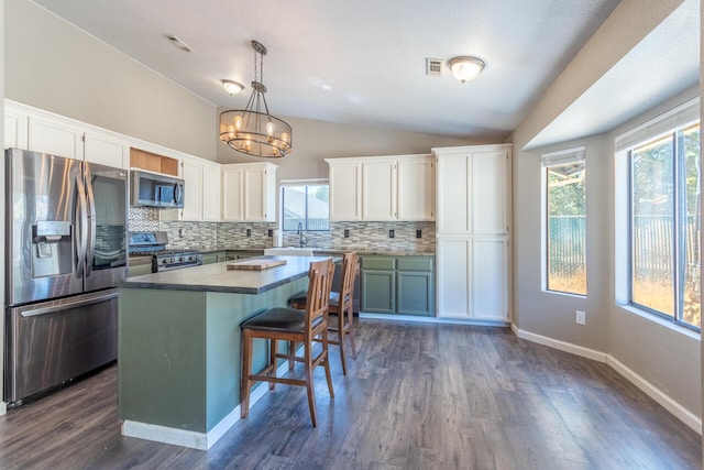 kitchen with white cabinets, visible vents, appliances with stainless steel finishes, and vaulted ceiling