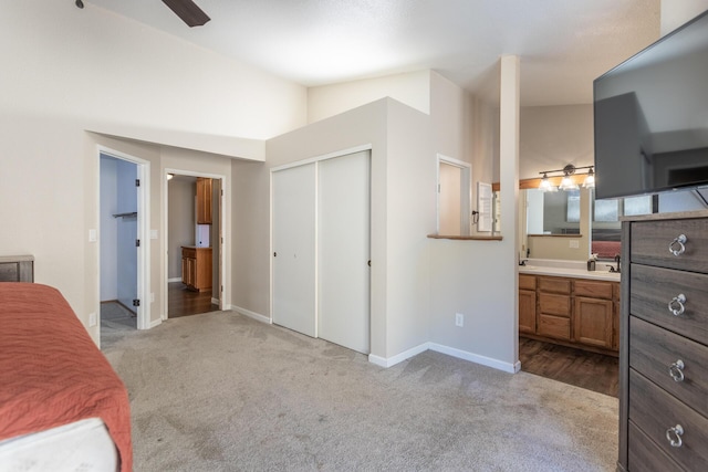 bedroom with carpet, baseboards, vaulted ceiling, and a closet