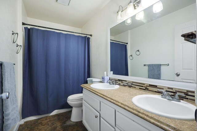 bathroom featuring vanity, tasteful backsplash, and toilet