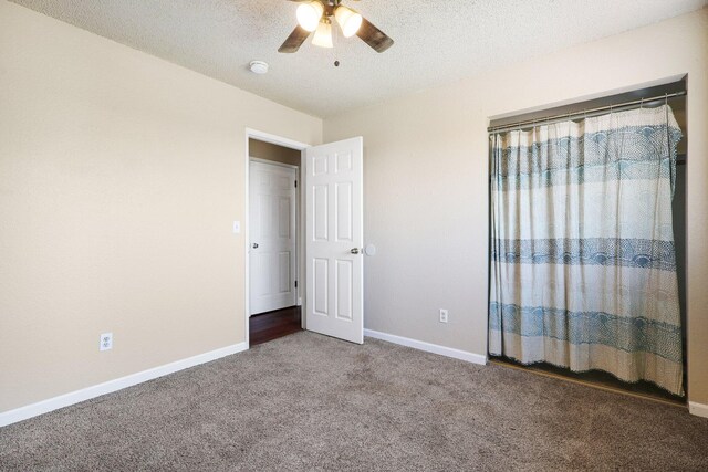 unfurnished bedroom featuring ceiling fan, carpet floors, and a textured ceiling