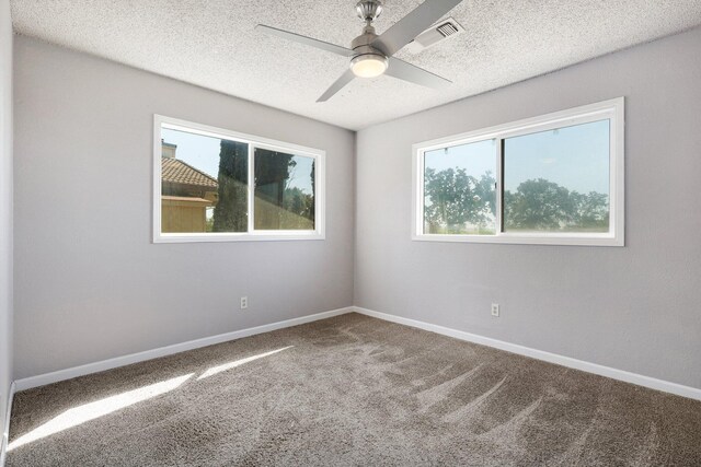 carpeted empty room featuring a textured ceiling and ceiling fan