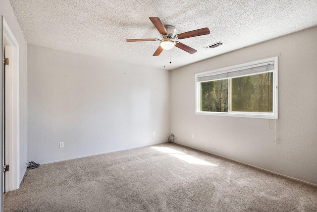 empty room featuring a textured ceiling, ceiling fan, and carpet