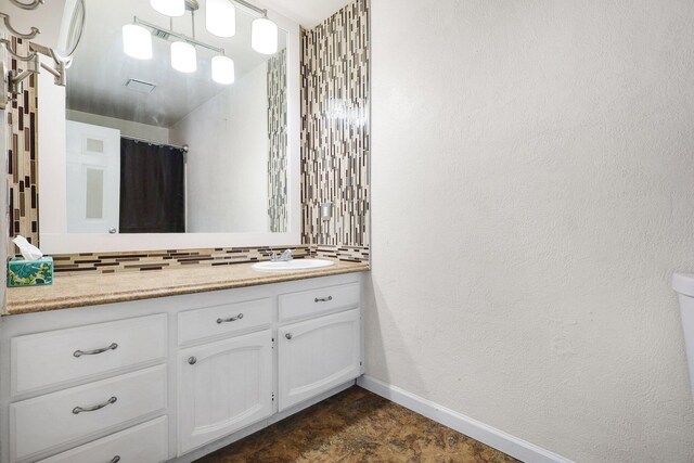 bathroom featuring a shower with curtain, backsplash, and vanity