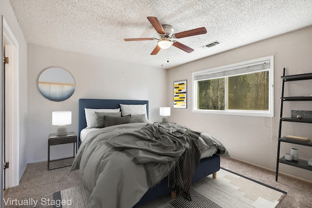 bedroom featuring ceiling fan, carpet, and a textured ceiling