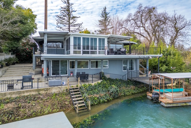 rear view of property featuring a balcony and a deck with water view