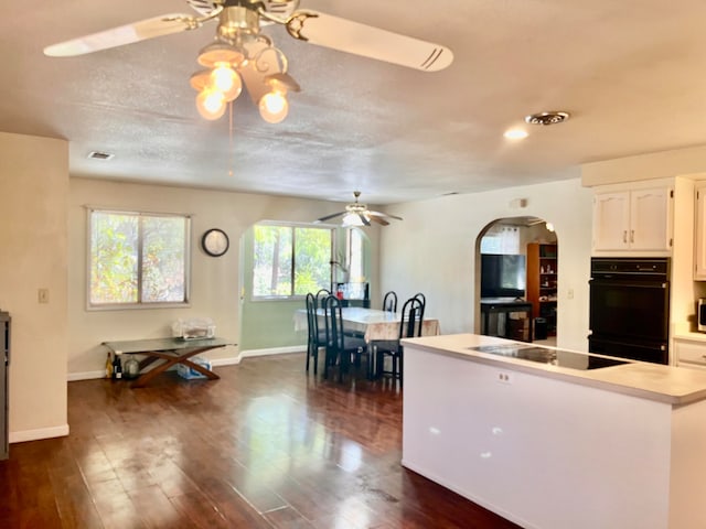 kitchen with white cabinets, dark wood-type flooring, ceiling fan, and black appliances