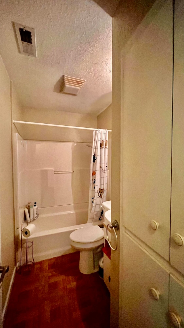 bathroom with shower / bathtub combination with curtain, toilet, and a textured ceiling