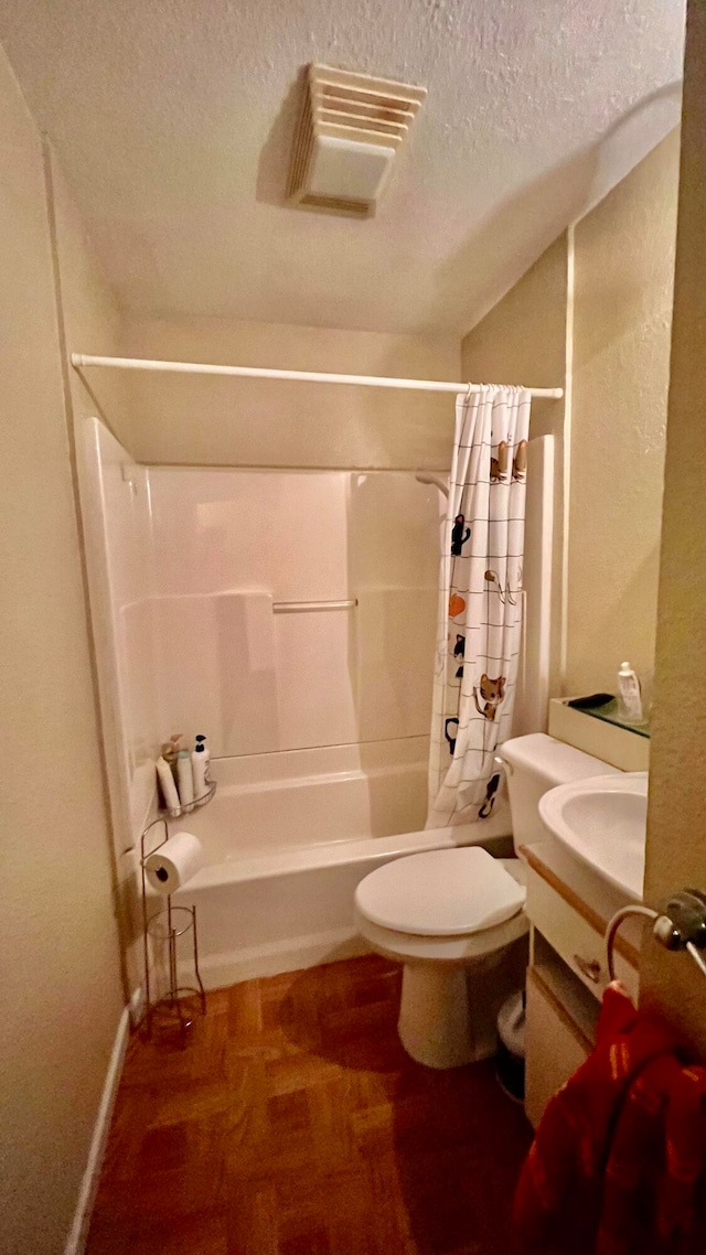 full bathroom featuring vanity, toilet, shower / tub combo with curtain, and a textured ceiling