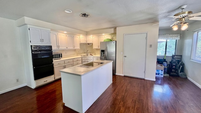 kitchen featuring black appliances, sink, ceiling fan, dark wood-type flooring, and white cabinets