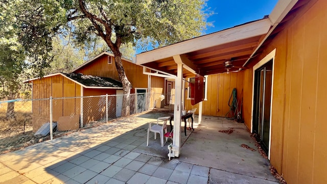 view of patio with ceiling fan and a shed