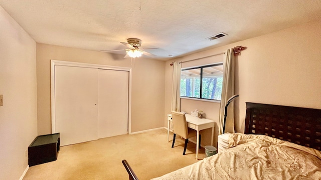 bedroom with light carpet, a textured ceiling, ceiling fan, and a closet