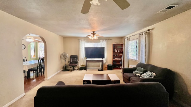 living room featuring a textured ceiling, ceiling fan, and carpet flooring