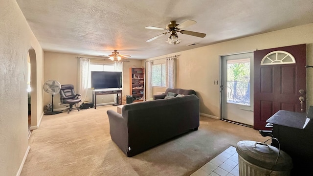 carpeted living room with a textured ceiling and ceiling fan